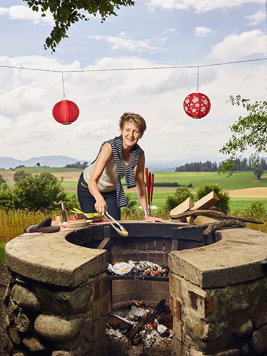 Bundesrätin Simonetta Sommaruga legt eine Kartoffel auf den Grill